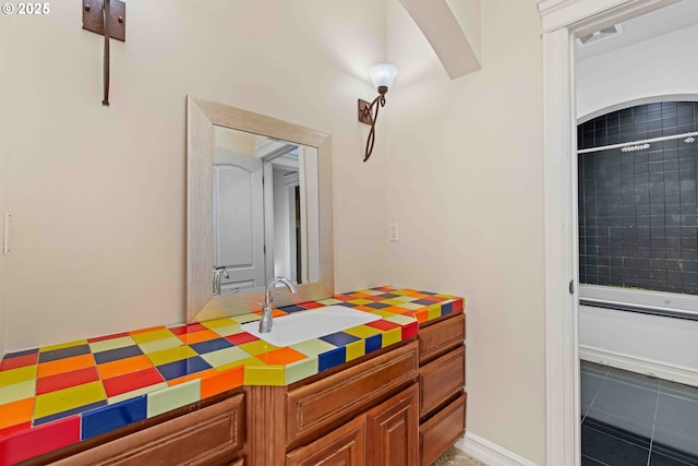 interior space with tile patterned flooring, vanity, and tiled shower / bath combo