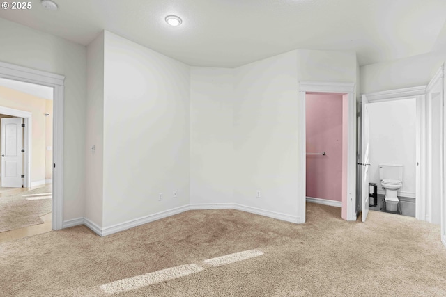 unfurnished bedroom featuring carpet flooring and ensuite bathroom