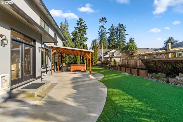 view of yard with french doors, a patio, and a hot tub