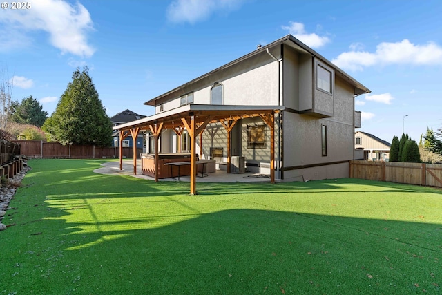 back of property with a lawn, a patio area, and a hot tub