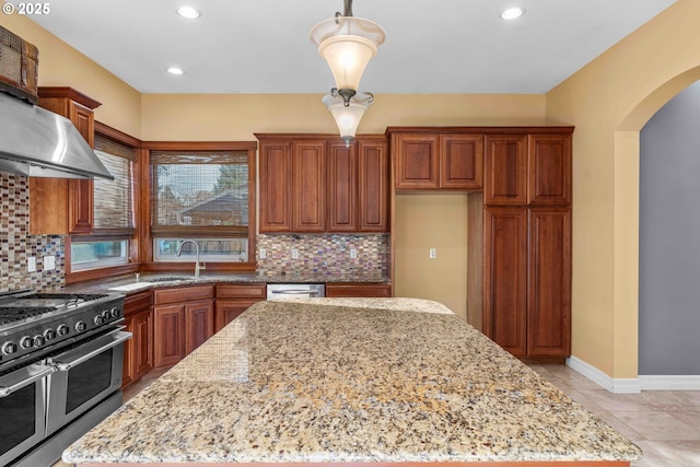 kitchen featuring light stone countertops, pendant lighting, backsplash, and stainless steel appliances