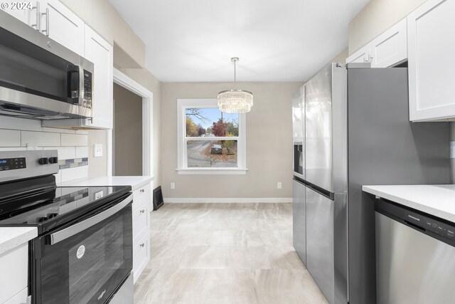 kitchen featuring white cabinetry, appliances with stainless steel finishes, backsplash, a notable chandelier, and pendant lighting