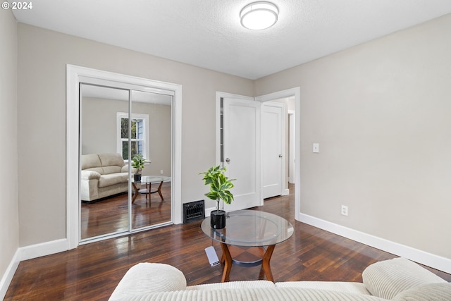 sitting room featuring dark hardwood / wood-style flooring and a textured ceiling