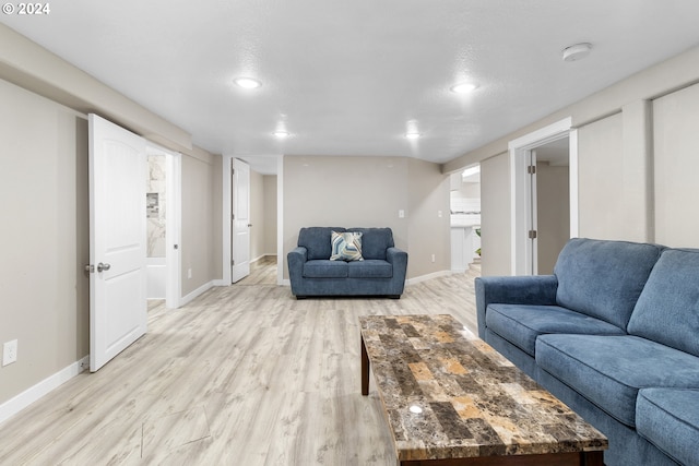 living room featuring light wood-type flooring and a textured ceiling