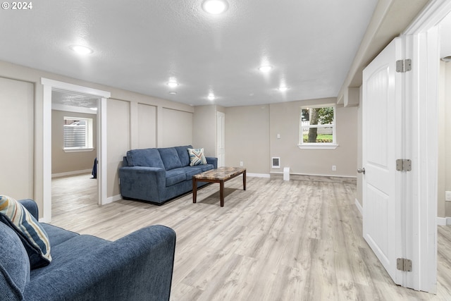 living room featuring a textured ceiling and light hardwood / wood-style flooring