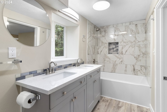 bathroom featuring a textured ceiling, tiled shower / bath combo, hardwood / wood-style flooring, and vanity