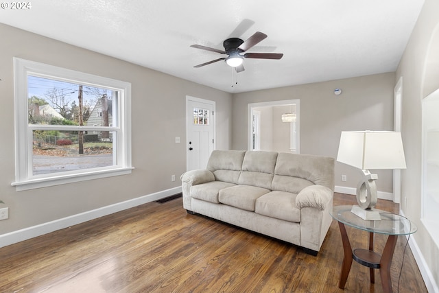 living room featuring ceiling fan and dark hardwood / wood-style floors