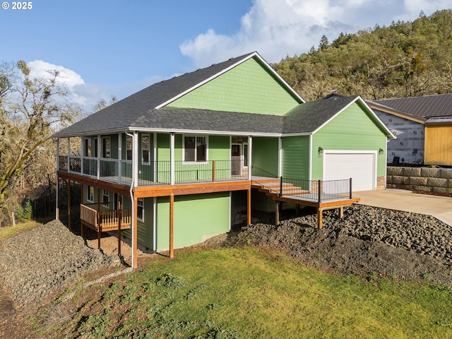 125 Sylvan Vista Ct, Roseburg, OR 97471 - back of property featuring an attached garage, a porch, driveway, roof with shingles, and a lawn