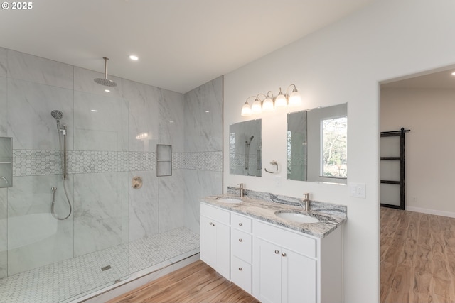 bathroom featuring tiled shower, hardwood / wood-style floors, and vanity