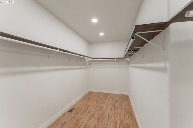 walk in closet with hardwood / wood-style floors