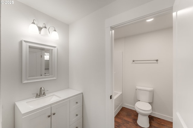 bathroom featuring a tub, toilet, vanity, and hardwood / wood-style flooring