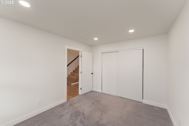 unfurnished bedroom featuring a closet and light colored carpet