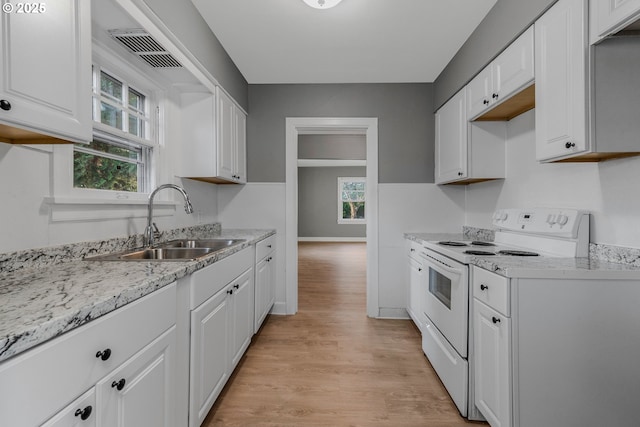 2849 Florida St, Longview, WA 98632 - kitchen featuring white range with electric cooktop, light wood-type flooring, white cabinets, and light stone counters