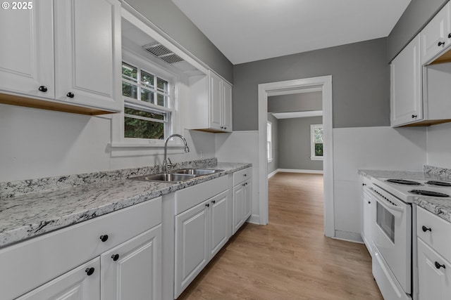 2849 Florida St, Longview, WA 98632 - kitchen with electric stove, light wood-style flooring, white cabinetry, and light stone counters