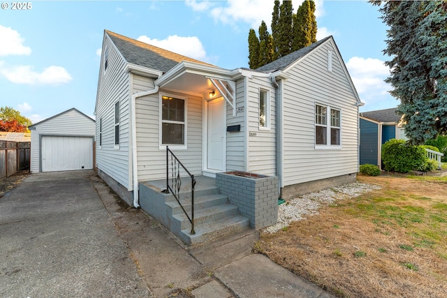 2849 Florida St, Longview, WA 98632 - view of front of house featuring an outdoor structure, a detached garage, asphalt driveway, and roof with shingles