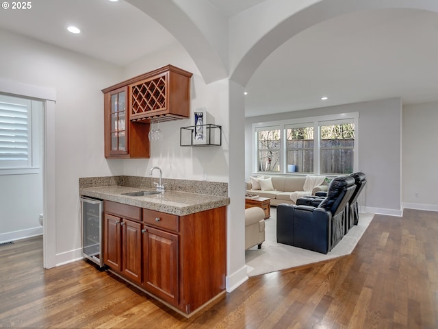 kitchen with wine cooler, sink, and light hardwood / wood-style flooring