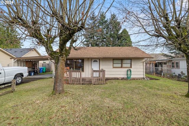 ranch-style home featuring a front lawn and a carport