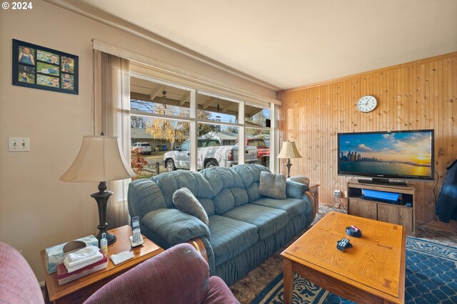 carpeted living room with wooden walls