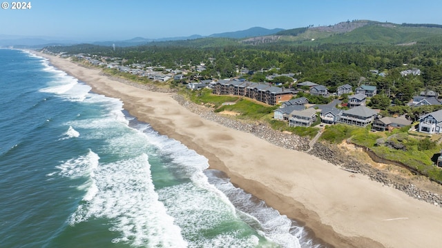 drone / aerial view featuring a water and mountain view and a beach view