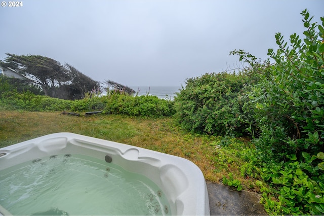 view of pool featuring a water view and a hot tub