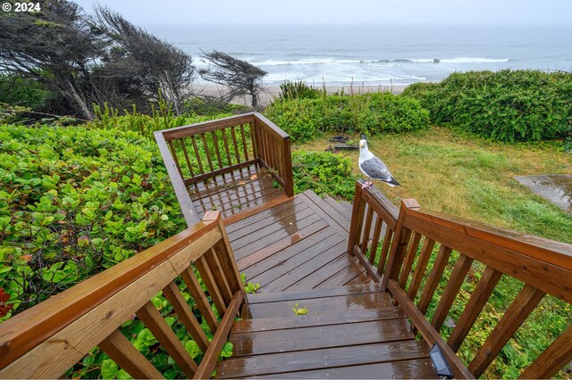 wooden deck featuring a lawn and a water view