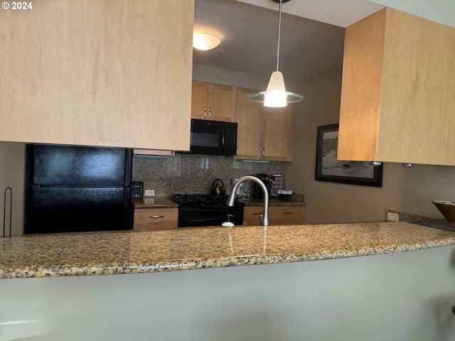 kitchen featuring pendant lighting, light brown cabinetry, tasteful backsplash, light stone counters, and black appliances