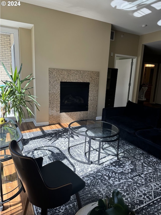 living room with hardwood / wood-style flooring and a high end fireplace