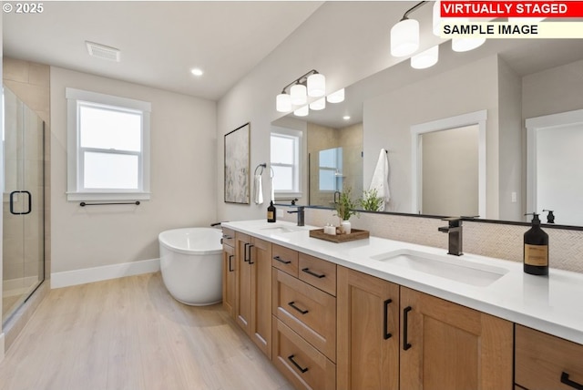 bathroom with vanity, shower with separate bathtub, and wood-type flooring