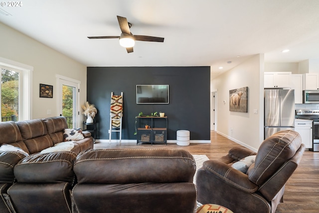 living room featuring ceiling fan and dark wood-type flooring