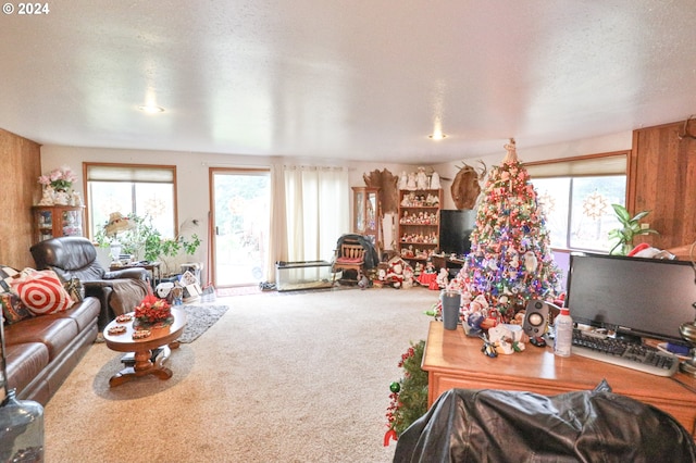 carpeted living room featuring wood walls and a textured ceiling