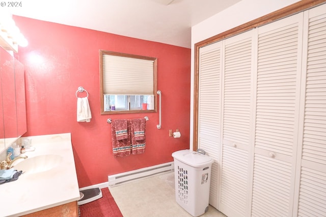 bathroom with a closet, a baseboard radiator, vanity, and baseboards