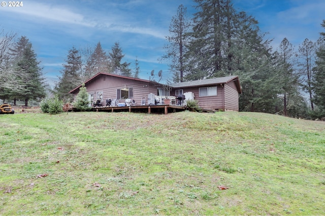 back of property with a lawn and a wooden deck