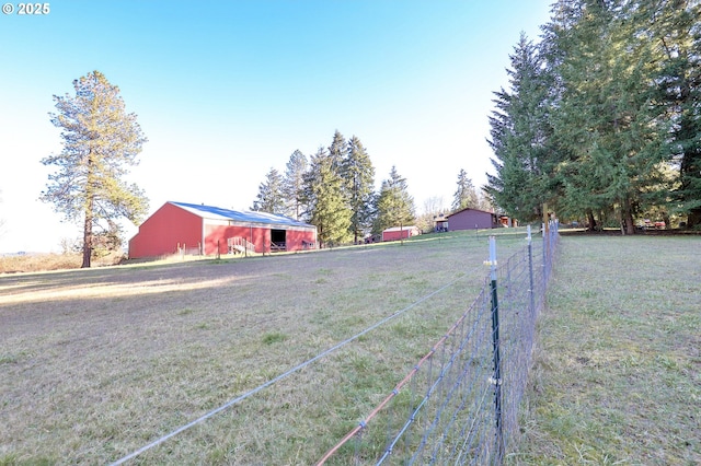 view of yard featuring fence, an outbuilding, and an outdoor structure