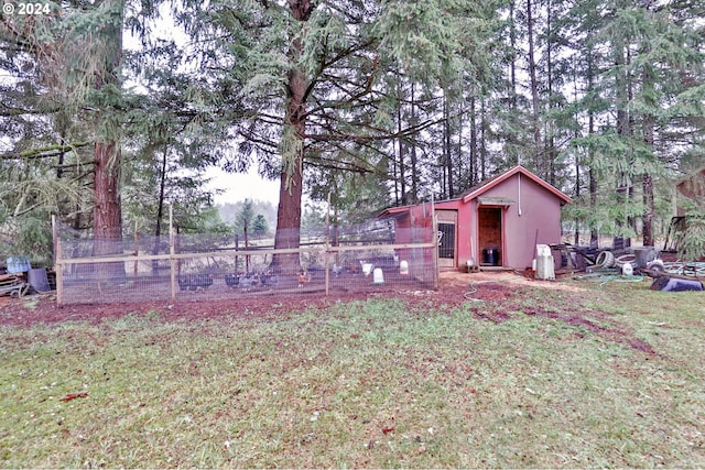 view of yard with fence, exterior structure, and an outdoor structure