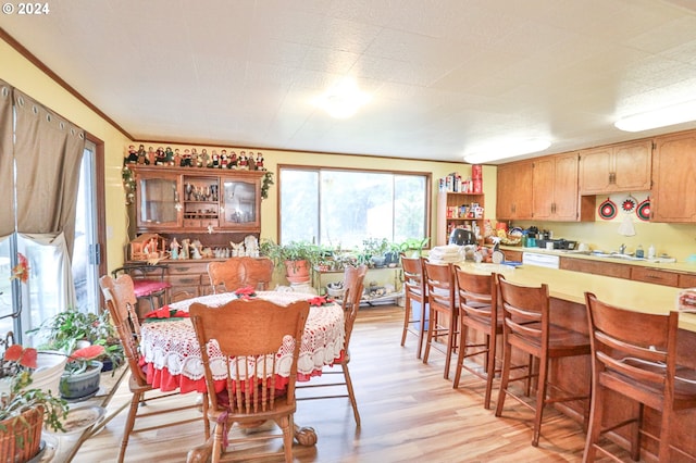 dining room featuring light wood finished floors and ornamental molding