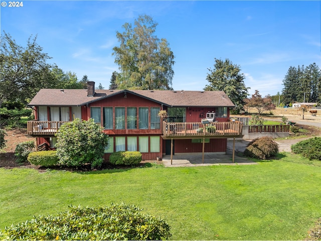 back of property featuring a wooden deck and a lawn