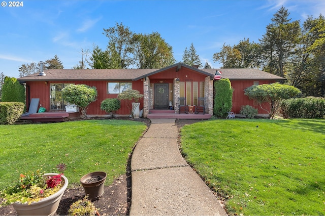 single story home with a wooden deck and a front lawn