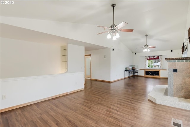 unfurnished living room featuring vaulted ceiling, ceiling fan, built in features, and hardwood / wood-style flooring