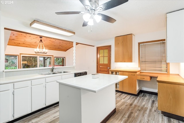 kitchen with pendant lighting, white cabinets, a center island, sink, and light hardwood / wood-style flooring