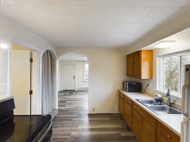 kitchen featuring dark hardwood / wood-style floors, sink, appliances with stainless steel finishes, and a baseboard heating unit