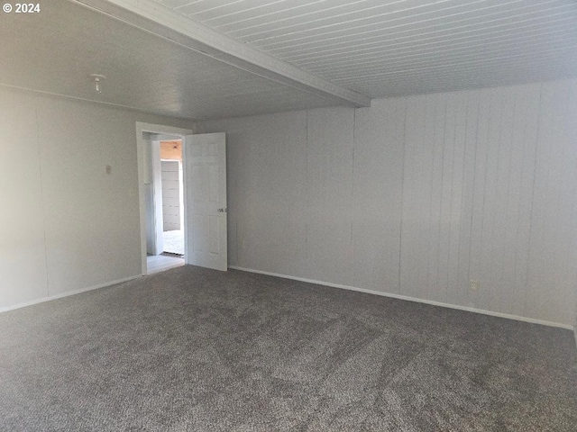 empty room with carpet and beamed ceiling