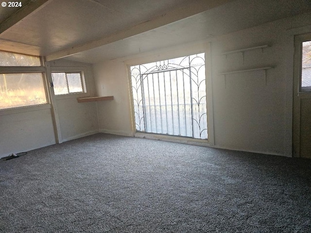 spare room with carpet flooring and beam ceiling