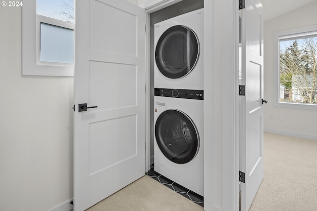 clothes washing area featuring light carpet and stacked washer and dryer