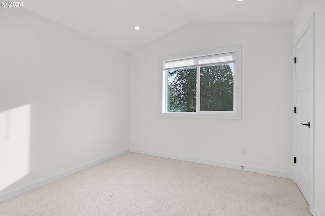 unfurnished room featuring lofted ceiling and light carpet