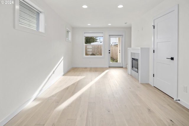 unfurnished living room featuring a fireplace and light hardwood / wood-style floors