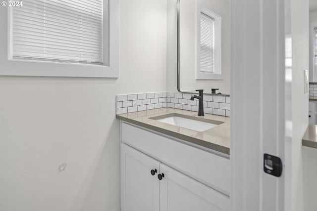 bathroom with tasteful backsplash and vanity