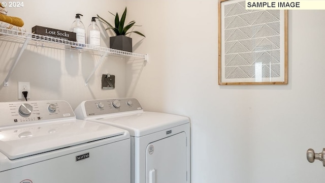 clothes washing area with washer and clothes dryer