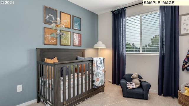 carpeted bedroom featuring a nursery area