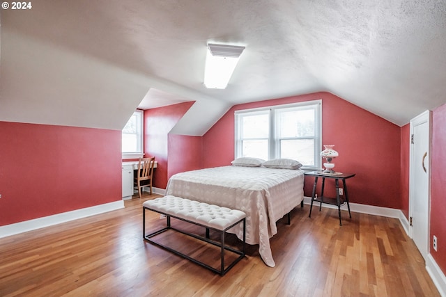 bedroom with hardwood / wood-style floors and vaulted ceiling