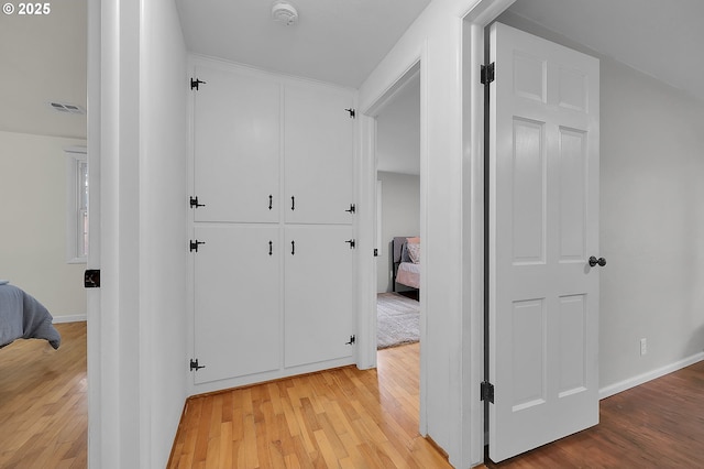 hallway with light hardwood / wood-style floors